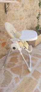 a white chair sitting on the floor next to a stone wall at The Mousehouse in Áno Rínglia