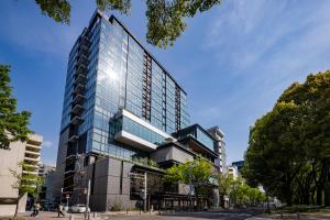 a tall glass building on a city street at TIAD, Autograph Collection in Nagoya