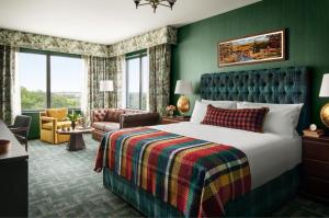 a hotel room with a bed and a chair at Graduate East Lansing in East Lansing