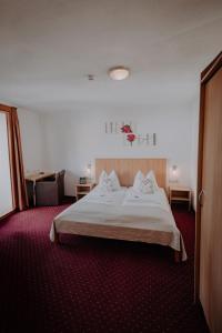 um quarto de hotel com uma cama e um tapete vermelho em Sporthotel Kitz em Bruck an der Grossglocknerstrasse