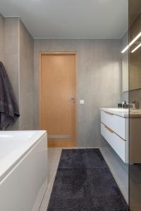 La salle de bains est pourvue d'une baignoire et d'une porte en bois. dans l'établissement Old town luxury penthouse apartment with Emajõgi view, à Tartu