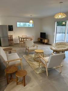 ein Wohnzimmer mit Stühlen, Tischen und einem TV in der Unterkunft Villa mina in Ghisonaccia