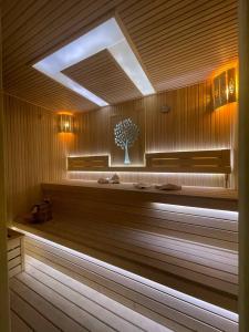 a sauna with a bench and a tree in it at Oqshom Plaza Hotel in Qarshi