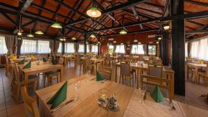 an empty restaurant with wooden tables and chairs at Bungalows Korana - Campsite Korana in Seliste Dreznicko