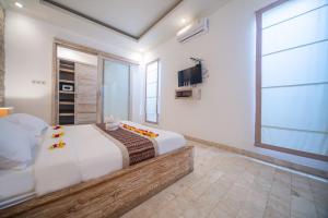 a bedroom with a large bed and a tv at Shakti Villa Umalas in Canggu