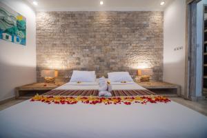 a bedroom with a large bed with flowers on it at Shakti Villa Umalas in Canggu
