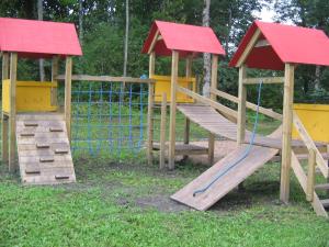 un parque infantil con 2 estructuras de madera y un tobogán en Kilplaste küla kämpingud, 