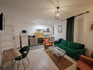 ein Wohnzimmer mit einem grünen Sofa und einer Küche in der Unterkunft Cosy Appartement T2 proche Paris in Ivry-sur-Seine