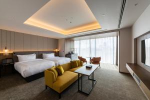 a hotel room with a bed and a couch at TIAD, Autograph Collection in Nagoya