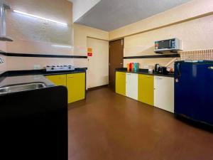 eine Küche mit gelben und weißen Schränken und einem Waschbecken in der Unterkunft Par-X Mist View 9A Garden Villa 3BHK in Lonavla