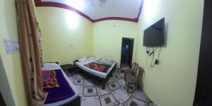 a small room with a bed and a television at Raj palace in Uttarkāshi