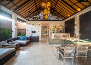 a large living room with a table and a kitchen at Shakti Villa Umalas in Canggu