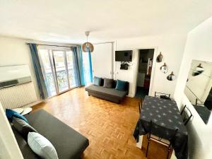 a living room with a couch and a table at Renovated Charming Apt Ideal to visit Paris in Clichy
