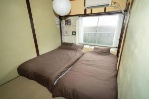 a small bed in a room with a window at I LOVE OSAKA in Osaka