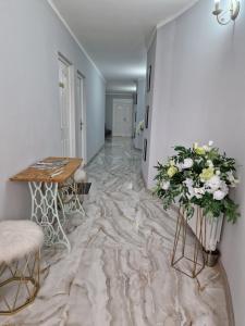uma sala de estar com mesa e flores no chão em Caprice Deluxe Accomodation em Drobeta-Turnu Severin