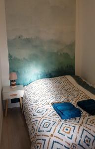 um quarto com uma cama com um quadro na parede em Les Studio Cosy - Lunéville centre em Lunéville