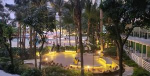 een uitzicht over een park met palmbomen in de nacht bij Azure Beachview Affordable Price in Manilla