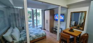 - une chambre avec un lit, une table et un miroir dans l'établissement Azure Beachview Affordable Price, à Manille