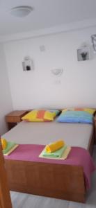1 dormitorio con 2 camas con sábanas y almohadas coloridas en Apartment Kristofor Rab en Kampor