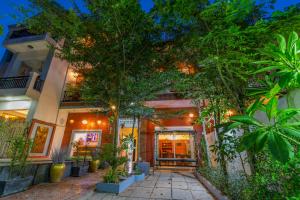 un bâtiment avec des arbres et des plantes devant lui dans l'établissement Angkor Rithy Boutique Group, à Siem Reap