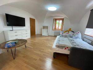 1 dormitorio con cama, mesa y TV en Ferienwohnung Sommeralm, en Arzberg