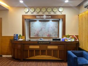 a reception area of a hospital with clocks on the wall at Hotel The Black Stone in Bangalore