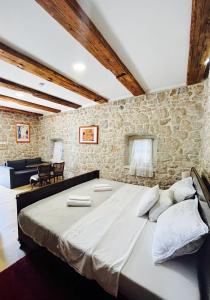 GrudeにあるVilla Lucaの石壁の客室の大型ベッド1台分です。