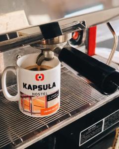 a cup of coffee in a coffee machine at Kapsuła Hostel Warszawa in Warsaw