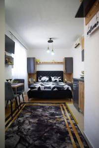 a bedroom with a bed and a table and a kitchen at Luxury Apartment Milićević 2 in Trebinje +56 photos