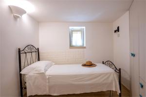 ein Schlafzimmer mit einem Bett mit Hut darauf in der Unterkunft Trullo Encanto with pool in Ceglie Messapica