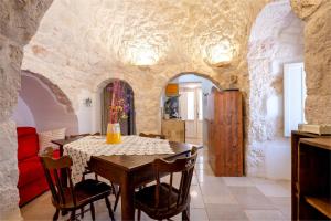 eine Küche und ein Esszimmer mit einem Tisch und Stühlen in der Unterkunft Trullo Encanto with pool in Ceglie Messapica