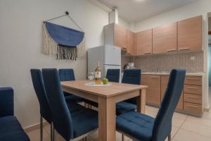 een keuken met een houten tafel en blauwe stoelen bij Kosmos Service Apartment Family City Center 4C in Thessaloniki