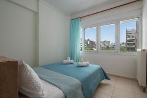 een slaapkamer met een bed en een groot raam bij Kosmos Service Apartment Family City Center 4C in Thessaloniki