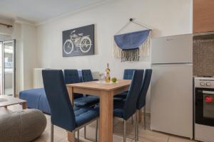 een keuken en eetkamer met een houten tafel en blauwe stoelen bij Kosmos Service Apartment Family City Center 4C in Thessaloniki