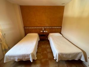 A bed or beds in a room at Hotel Restaurante Los Caños de la Alcaiceria