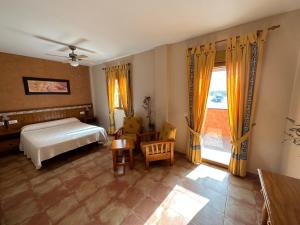 a bedroom with a bed and a window at Hotel Restaurante Los Caños de la Alcaiceria in Alhama de Granada