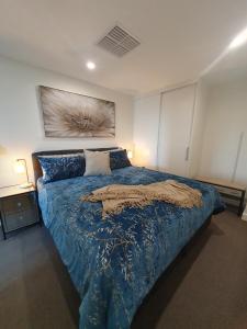 a bedroom with a bed with a blue comforter at Colley 11-11 Sub-Penthouse Luxurious Glenelg in Glenelg
