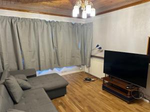 ein Wohnzimmer mit einem Sofa und einem Flachbild-TV in der Unterkunft Le Royal Residence 7 in London