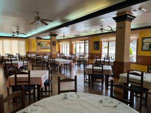 阿拉馬德格蘭娜達的住宿－卡諾斯阿爾採瑟餐廳酒店，一间带桌椅和吊扇的用餐室