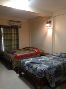 1 dormitorio con 2 camas en una habitación con ventana en S.K.House 2, en Chiang Mai