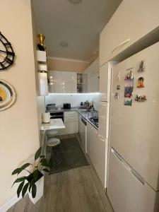 una cucina con armadietti bianchi e frigorifero di LIGHT HOUSE a Batumi