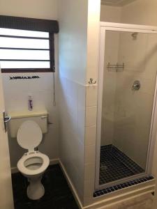 ein Badezimmer mit Toilette und Glasdusche in der Unterkunft Emma's Beach Cottage in Groot Brak Rivier + 38 Fotos