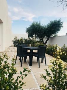 einen schwarzen Tisch und Stühle auf einer Terrasse in der Unterkunft Hotel Belsito in San Pietro in Bevagna