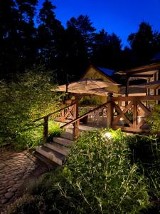 a wooden stairway with a fence and lights at night at Wiatraki Nature Resort in Olsztynek