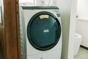 eine Waschmaschine im Bad neben einem WC in der Unterkunft Tokuto"King Villa" - Vacation STAY 73553v in Ieura