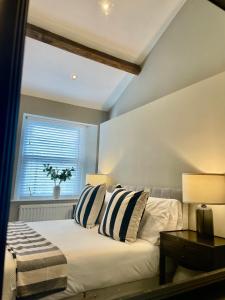 1 dormitorio con 1 cama con 2 almohadas y ventana en Queen's Cottage, Skipton, en Skipton