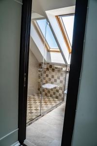 porta a vetri che conduce a un bagno con doccia di Casa Românească a Putna