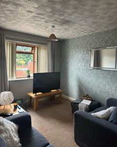 a living room with a couch and a television at Entire 2 bedroom house. in Rowley Regis