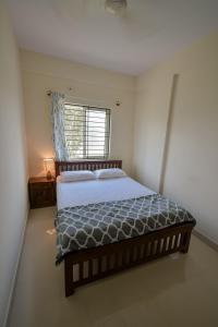 Schlafzimmer mit einem großen Bett und einem Fenster in der Unterkunft HomeSlice Sarjapur - 1BHK Serviced Apartment in Bangalore