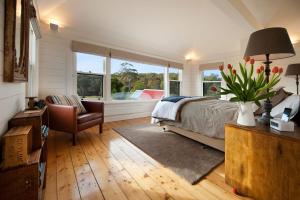 1 dormitorio con 1 cama, 1 silla y ventanas en Morgantis en Daylesford